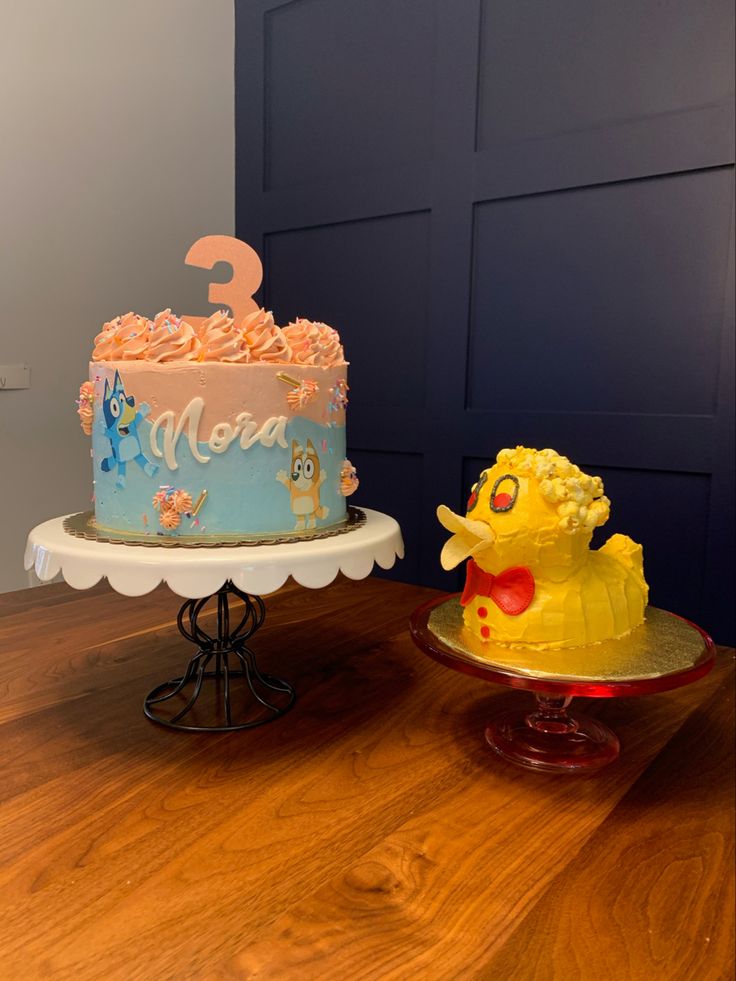 two birthday cakes sitting on top of a table next to each other, one has a rubber ducky