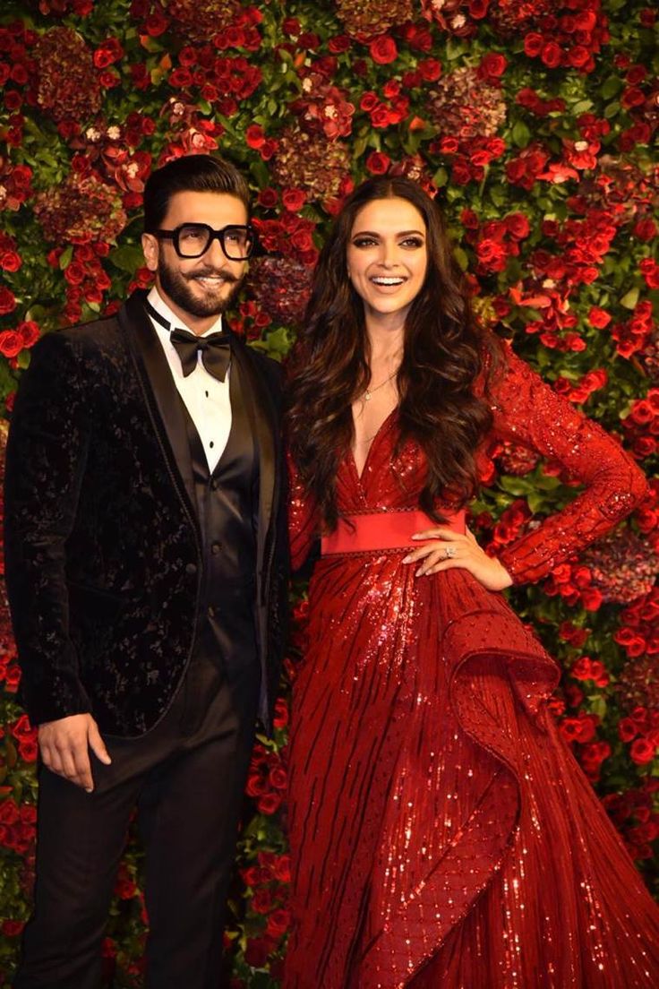 a man and woman in formal wear standing next to each other on a red carpet