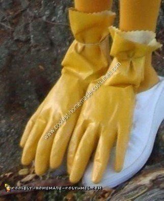 two yellow gloves with bows on them sitting on top of a white shoe next to a tree