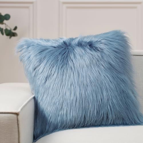 a blue furry pillow sitting on top of a white couch