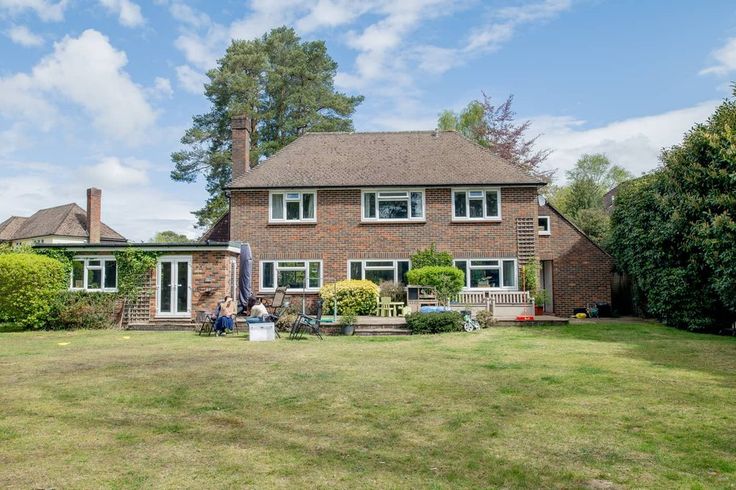 a large brick house sitting on top of a lush green field