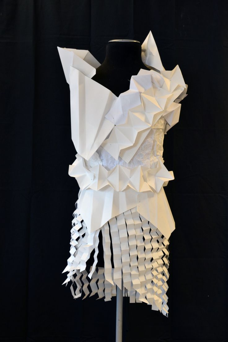 a mannequin made out of white paper on a black background