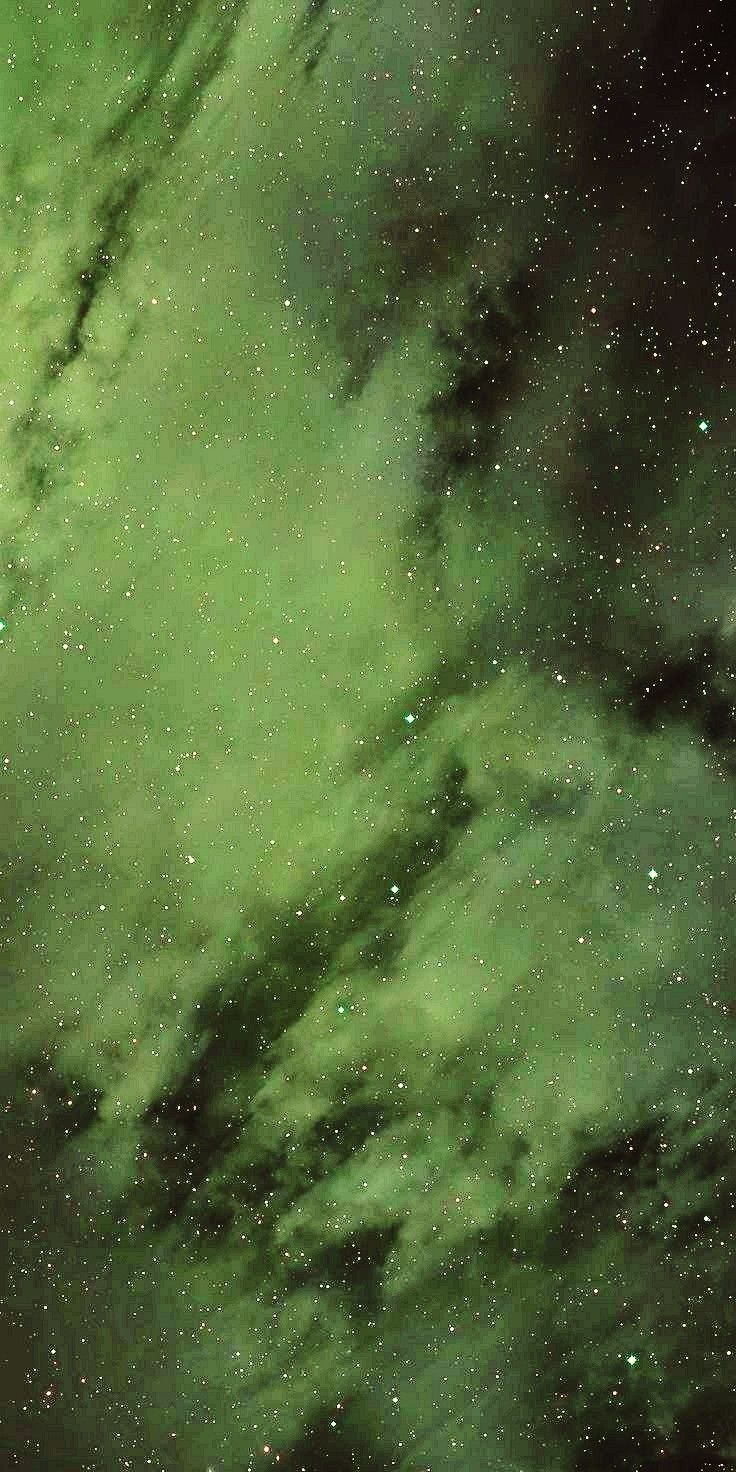 the night sky is filled with stars and green hues, as well as dark clouds