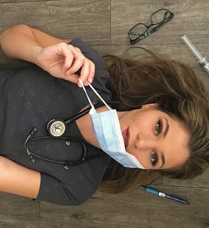 a young woman with a stethoscope on her head is laying on the floor