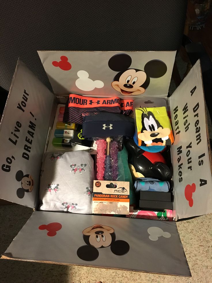 an open box with various items in it and mickey mouse on the inside, sitting on top of a table