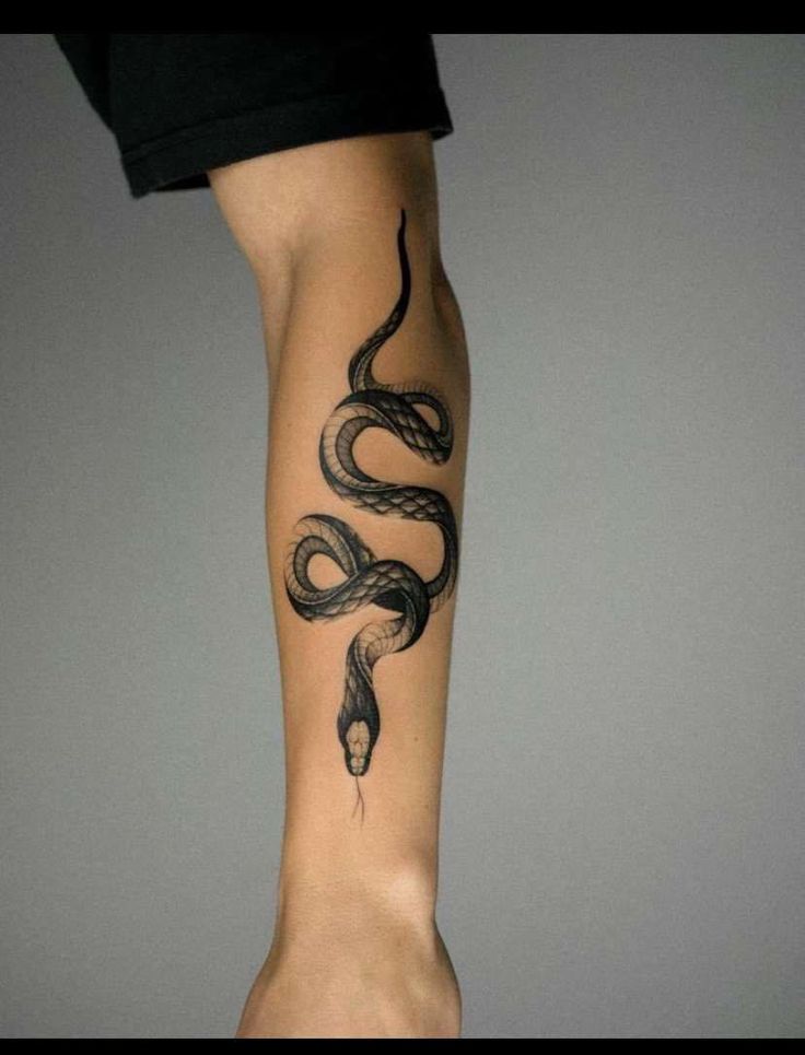 a woman's arm with a snake tattoo on it