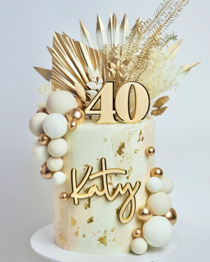 a white cake with gold decorations and the number forty on it