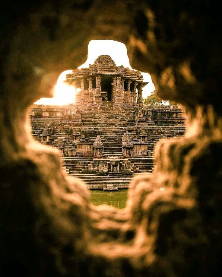 an ancient building is seen through a hole in the stone wall that looks like it has been built into the ground