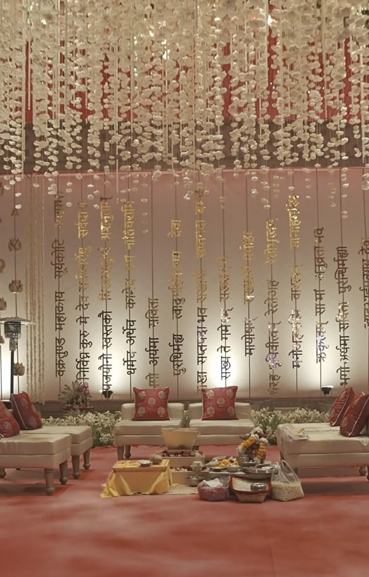 a living room filled with lots of couches and tables under chandelier hanging from the ceiling