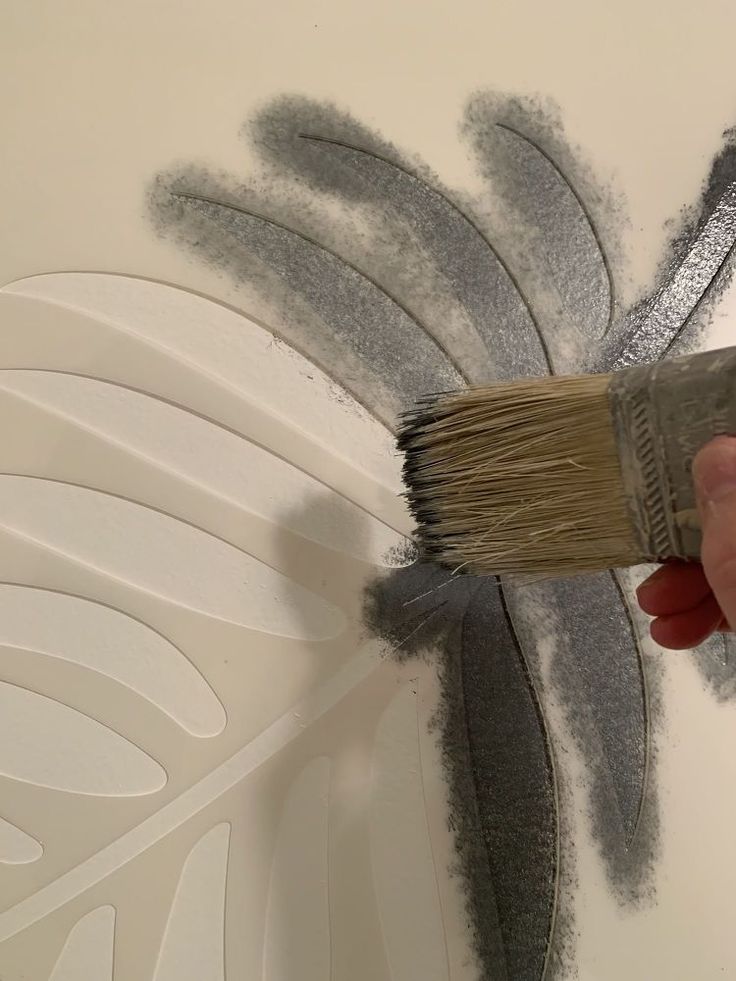 a person is using a brush to paint the wall