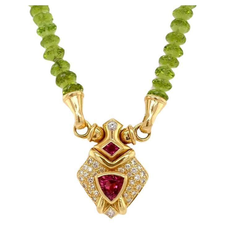 This exquisite necklace combines the vibrant allure of peridot briolettes with timeless elegance of 18kt gold, adorned with glistering diamonds and top-quality tourmalines. Its design harmoniously blends nature's brilliance and craftmanship, resulting in a stunning piece of jewelry that captivates with every glance. 18kt Yellow Gold Necklace with 99 Briolette Peridot Gems 158.80 carats, 1 Tourmaline 2.02 carats and 1 Ruby 0.18 with Diamonds 0.50 carats. Perfect High Jewelry Gift for Mom, Girlfri High Jewelry, Timeless Elegance, Tourmaline, Jewelry Gifts, Gifts For Mom, Gold Necklace, Jewelry Necklace Pendant, Gems, Yellow Gold