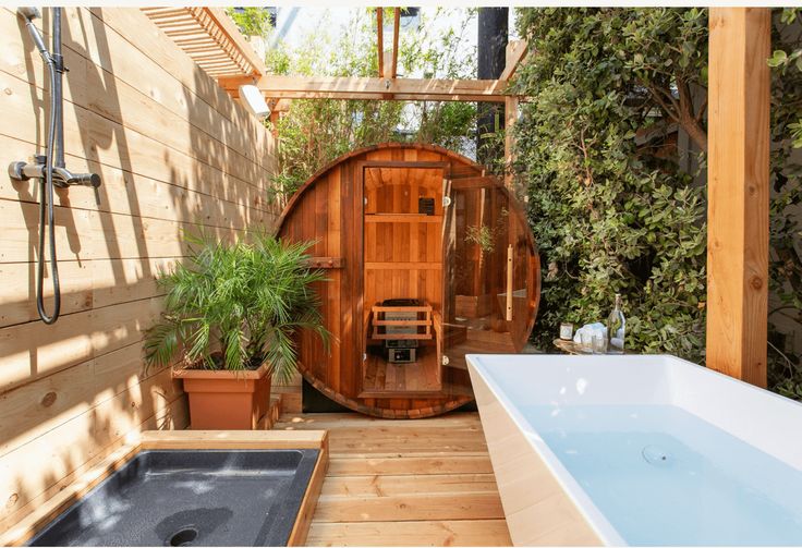 an outdoor jacuzzi tub in the middle of a wooden decked area with potted plants