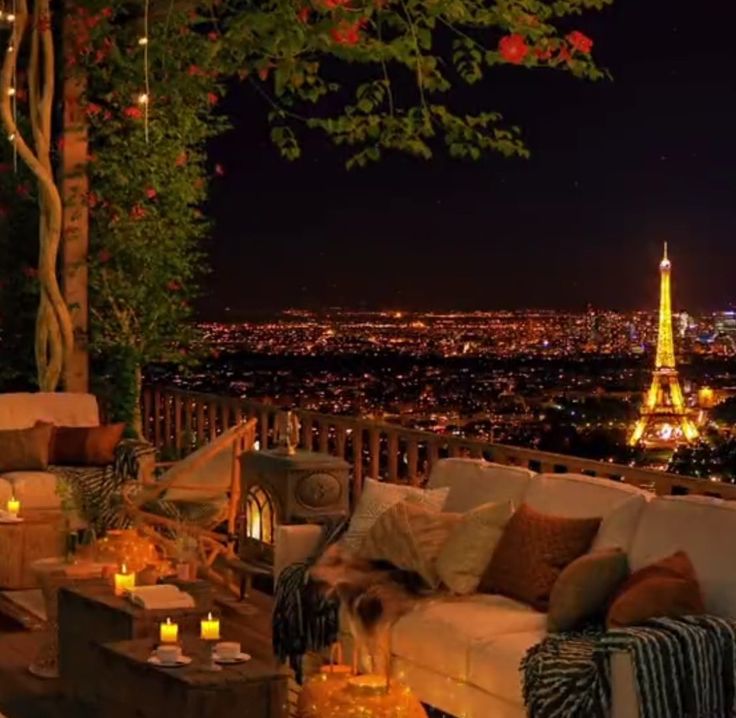 a living room filled with lots of furniture next to a night time cityscape