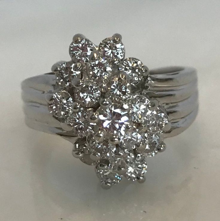 Here is an absolutely beautiful 14k white gold cluster diamond ring. This beauty is set with a total of 17 diamonds. These bright white diamonds will be causing a lot of attention! Materials: 14K White gold Stone: 1- RB .15cttw, 16- RB .80cttw Size: 8 Weight: 7.6 grams Sku: 21SB092318EVZ If you have any questions on this item, please message us! GandDJewelers.etsy.com For ring sizing, please contact us for information. Please note that all of our pieces have been analyzed & identified by a G Diamond Cluster Ring In Fine Jewelry Style, Diamond White Cluster Diamond Ring, Dazzling Diamond Cluster Ring With Single Cut Diamonds, Dazzling Cluster Diamond Ring With Single Cut Diamonds, Sparkling Cluster Diamond Ring, Dazzling Silver Diamond Ring In Cluster Shape, Fine Jewelry Diamond Ring With Single Cut Cluster, Dazzling Silver Diamond Ring With Cluster Shape, Dazzling Silver Cluster Diamond Ring