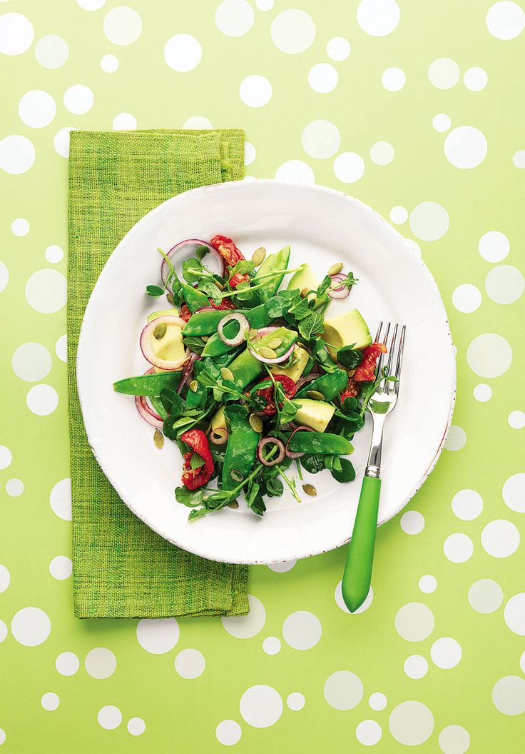 a white plate topped with salad next to a fork