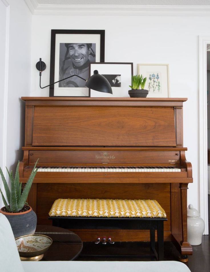 a living room with a piano and pictures on the wall