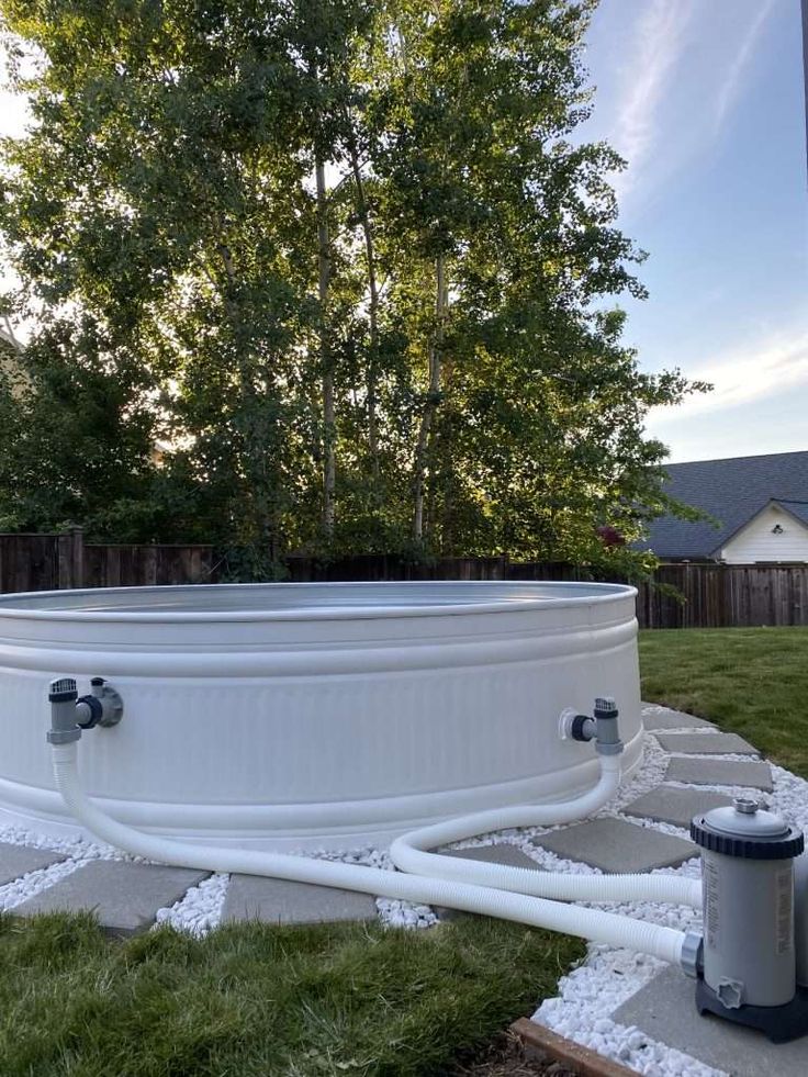 an above ground hot tub in the middle of a yard with trees and grass around it