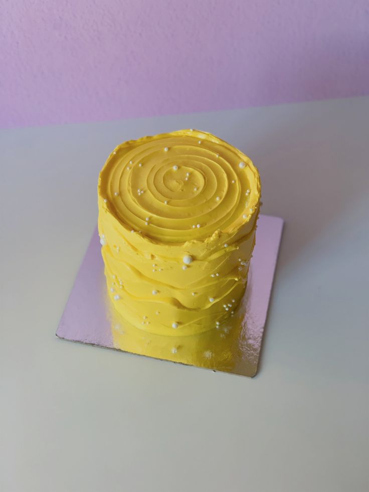 a yellow cake sitting on top of a purple plate