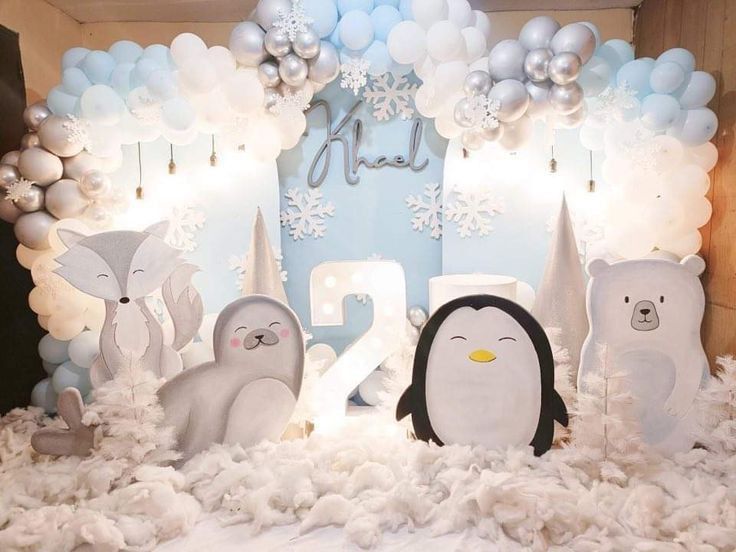 an image of a penguin and penguins in the snow with balloons on the wall behind them