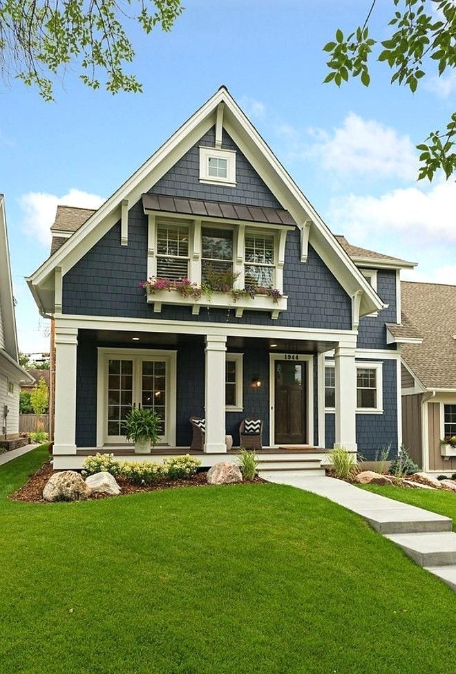 a house with blue siding and white trim on the front door, grass lawn and steps leading up to it