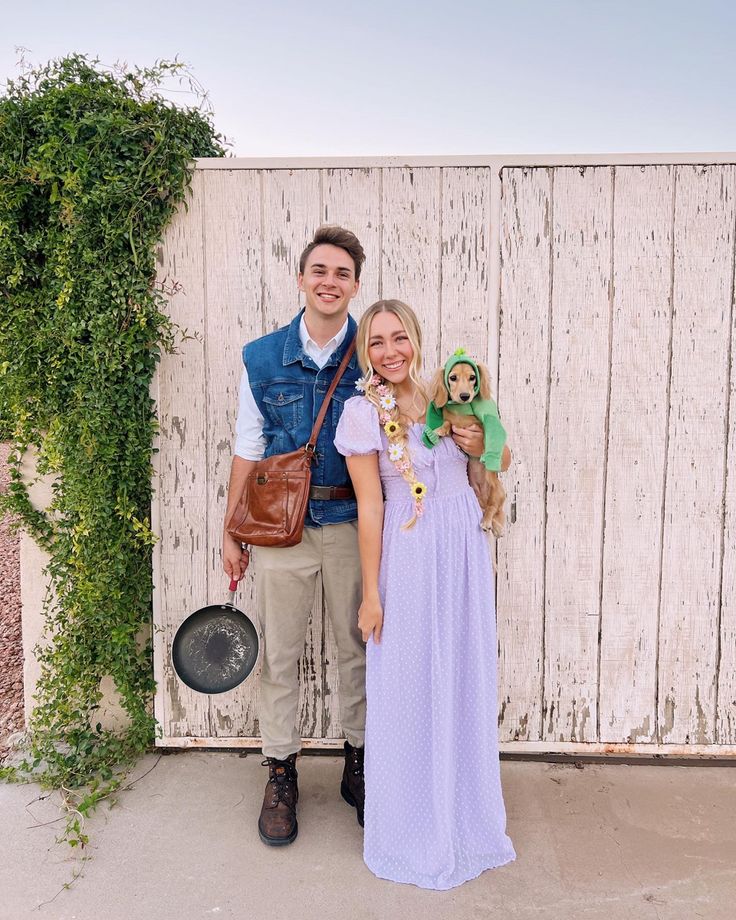 a man and woman standing next to each other in front of a wooden wall with plants