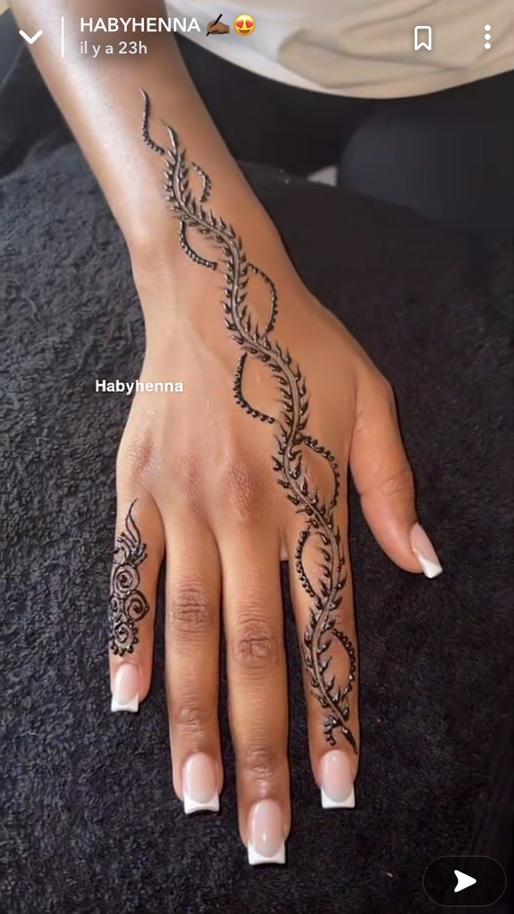 a woman's hand with henna tattoos on it