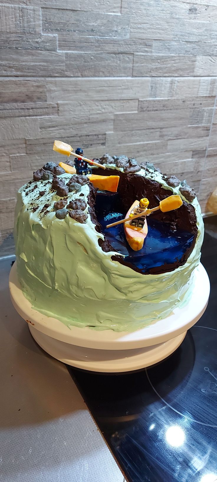 there is a cake with green frosting and orange slices on the top, sitting on a plate