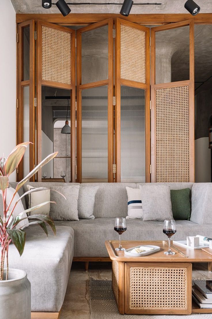 a living room filled with furniture and lots of wooden paneled walls next to a window