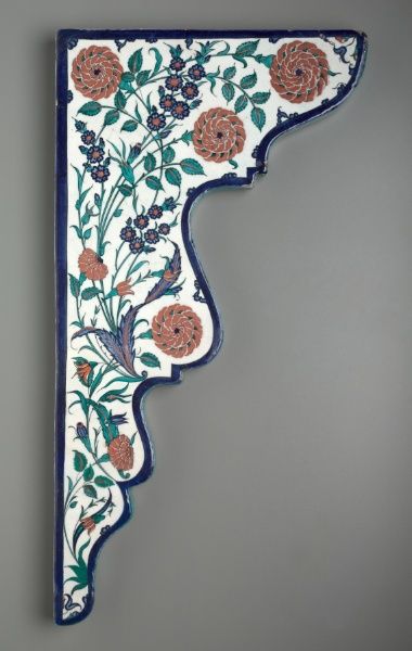 a decorative wall hanging with flowers and leaves on it's side, painted in blue and white