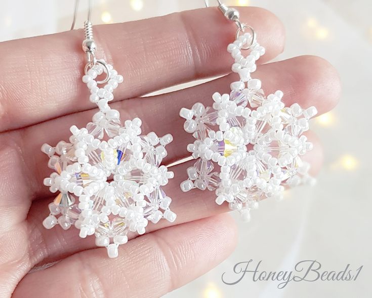 a pair of snowflake earrings is shown in the palm of someone's hand