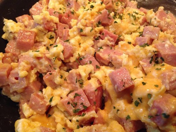 scrambled eggs with ham and cheese in a skillet