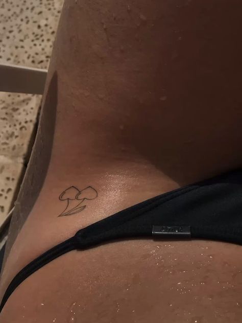 the back of a woman's stomach with a small tattoo on her left side