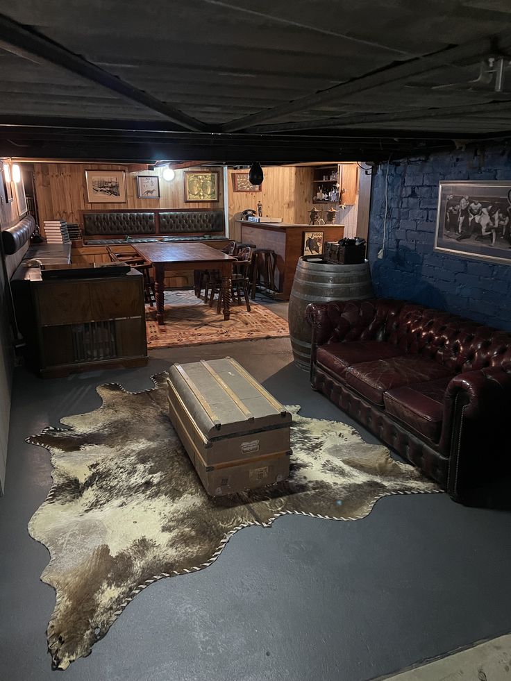 a living room filled with furniture and a cowhide rug on the floor in front of a bar