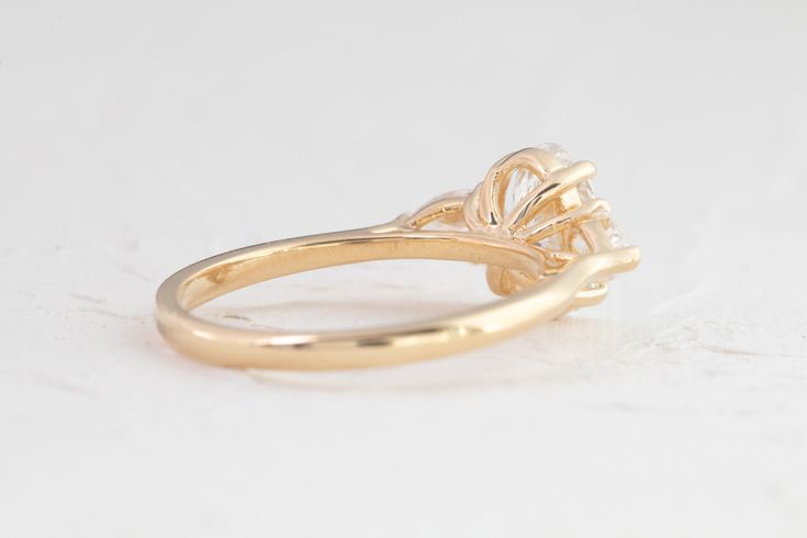 Our sophisticated Audrey ring features an oval center framed by 2 pear accents, expertly crafted to sparkle in all directions. Crafted for maximum brilliance, it's the perfect ring for a modern romantic. Shown with a ~8.5x6mm (~1.2ct) lab diamond in a 18K yellow gold setting, 1.6mm band, model ring size - 4.5 Show with a 2ct Marquise lab diamond crafted in 18K yellow gold, 1.8mm band Timeless Marquise Cut Halo Promise Ring, Elegant Oval Solitaire Halo Ring, Elegant Oval 14k Gold Diamond Ring, Timeless 14k Gold Oval Cluster Ring, Timeless Oval Cluster Ring In 14k Gold, Elegant 14k Gold Cluster Ring With Round Cut, Elegant 14k Gold Marquise Cut Wedding Ring, Timeless 14k Gold Halo Ring With Prong Setting, Classic 14k Gold Cluster Ring With Marquise Cut