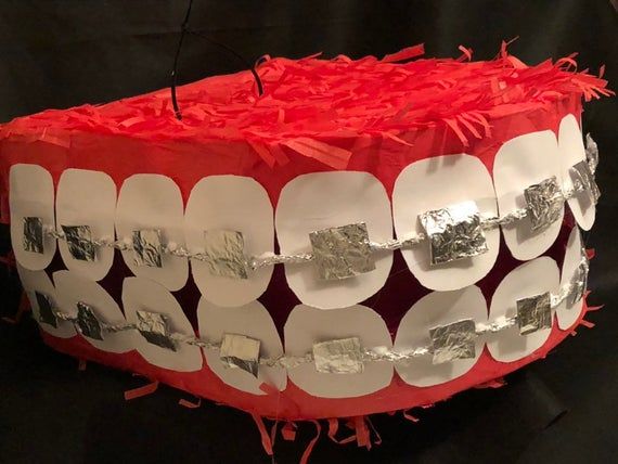 a cake made to look like a mouth with metal foil on it's sides