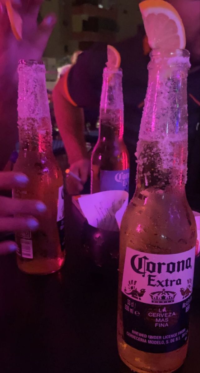 three bottles of corona beer sitting on top of a table