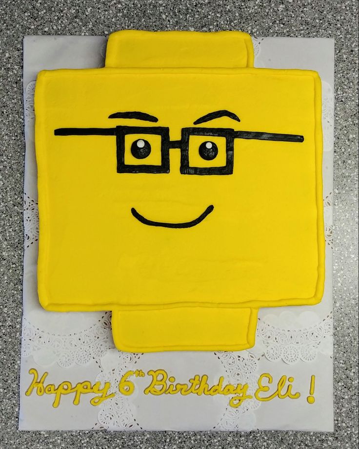 a birthday cake that looks like a lego character with glasses on it's face