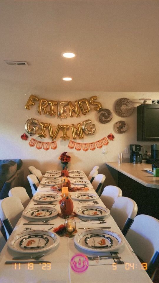 a long table with plates and silverware on it in front of a party banner