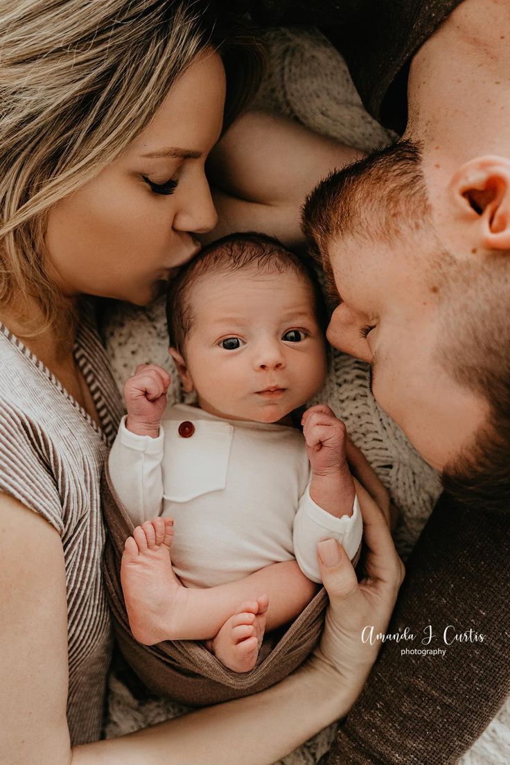 a man and woman holding a baby in their arms