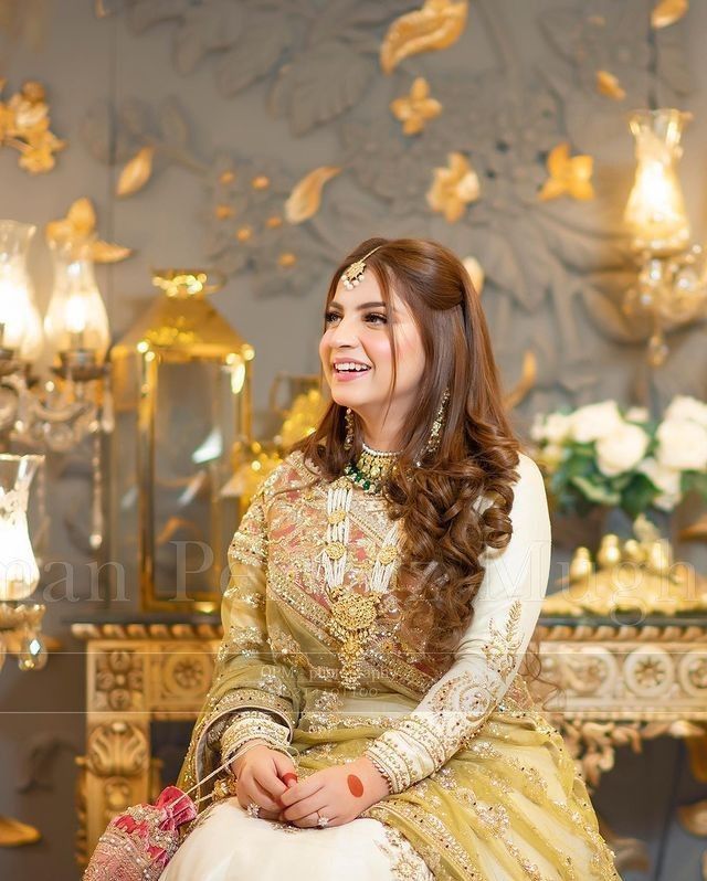 a woman in a gold and white dress sitting down