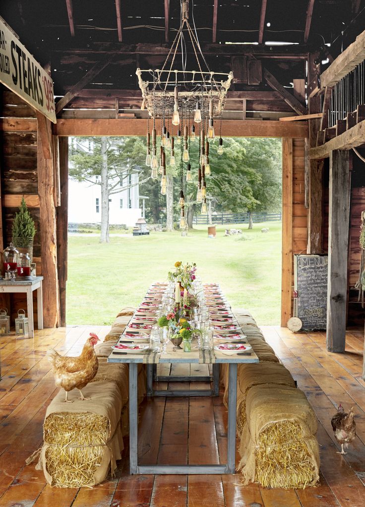 an outdoor dining area with chairs, tables and chandelier hanging from the ceiling