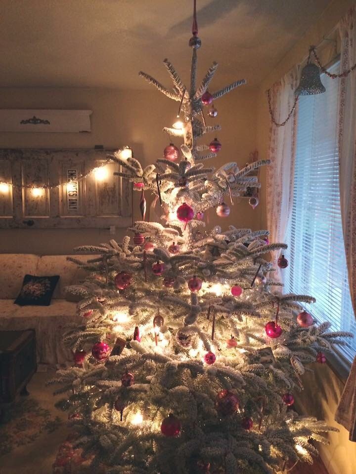 a white christmas tree with red and silver ornaments