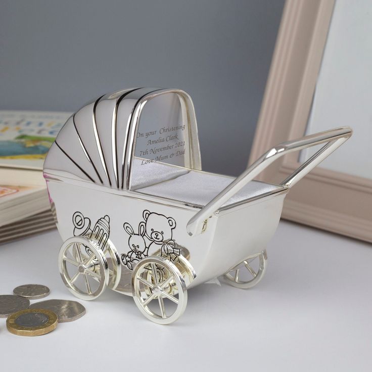 a small white baby carriage with coins next to it