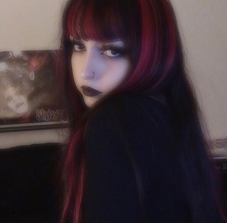 a woman with red hair and black makeup