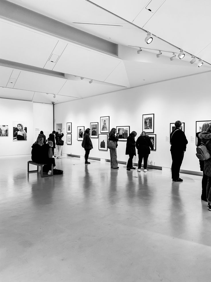 black and white photograph of people in an art gallery