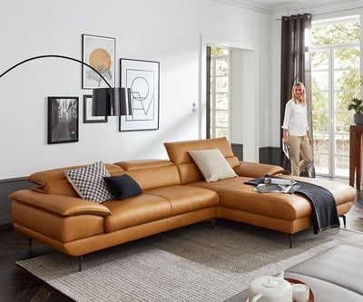 a living room filled with lots of furniture next to a large window and potted plant