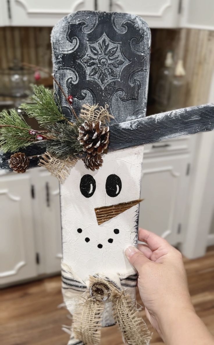 a person holding up a paper bag with a snowman on it