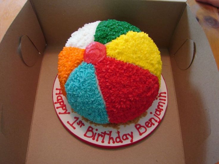 a birthday cake in a box with a beach ball design on the top and bottom