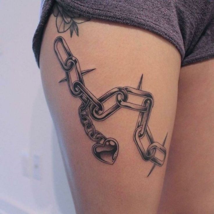 a woman's thigh with a chain tattoo on it