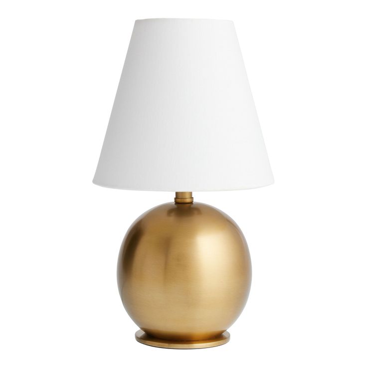 a gold table lamp with a white shade on the base and a light bulb in the middle